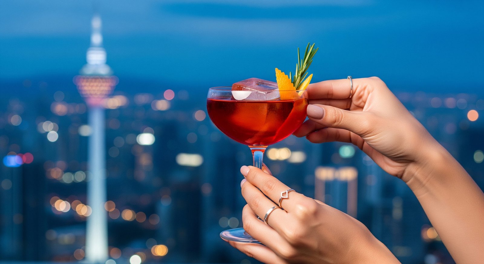Elegant craft cocktail service with KL Tower and sparkling city lights in the evening background